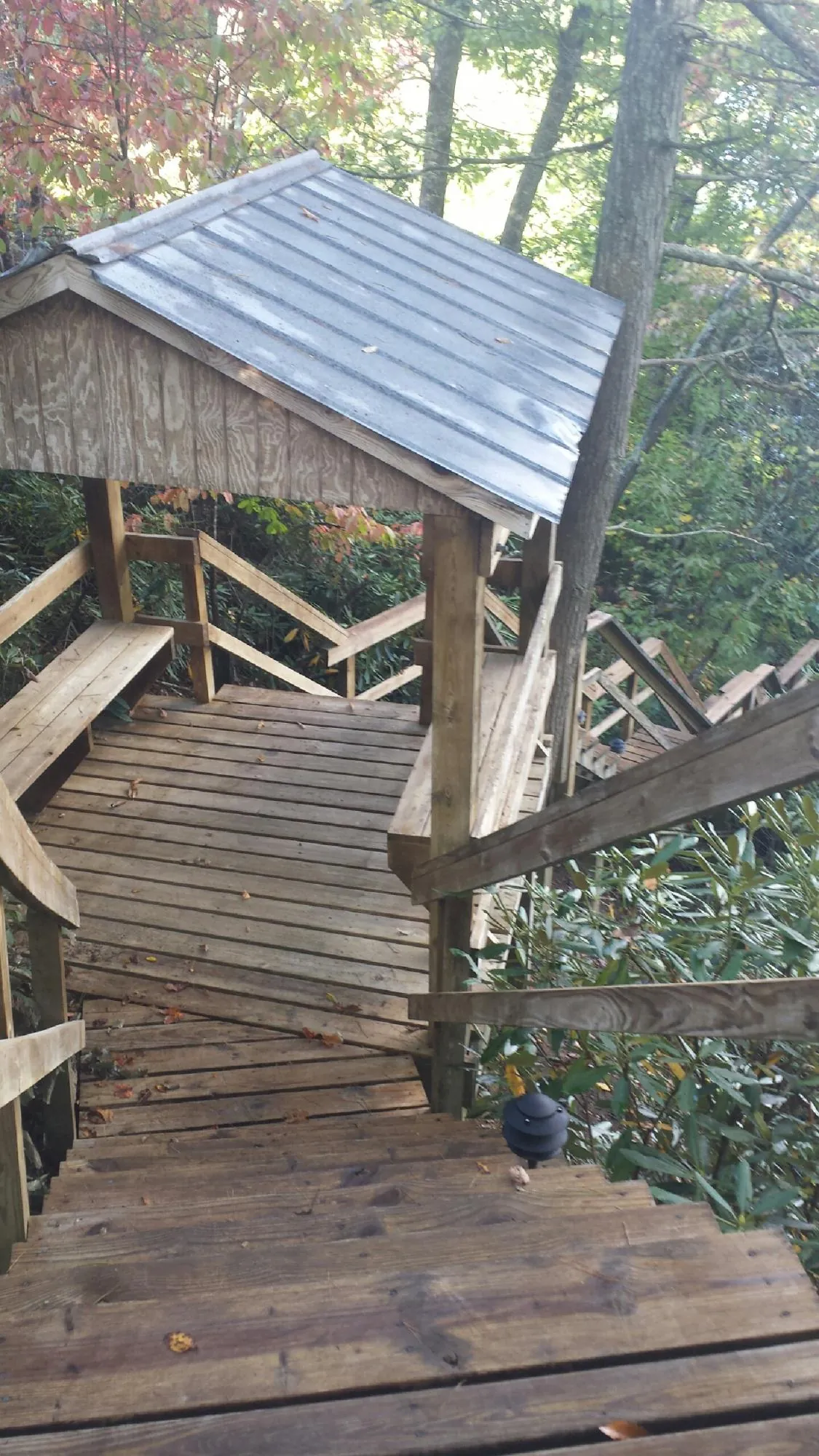 Metal roofed shelter over wooden steps on a wooded walkway — Skylight Repair & Installation work by our crew in Evant