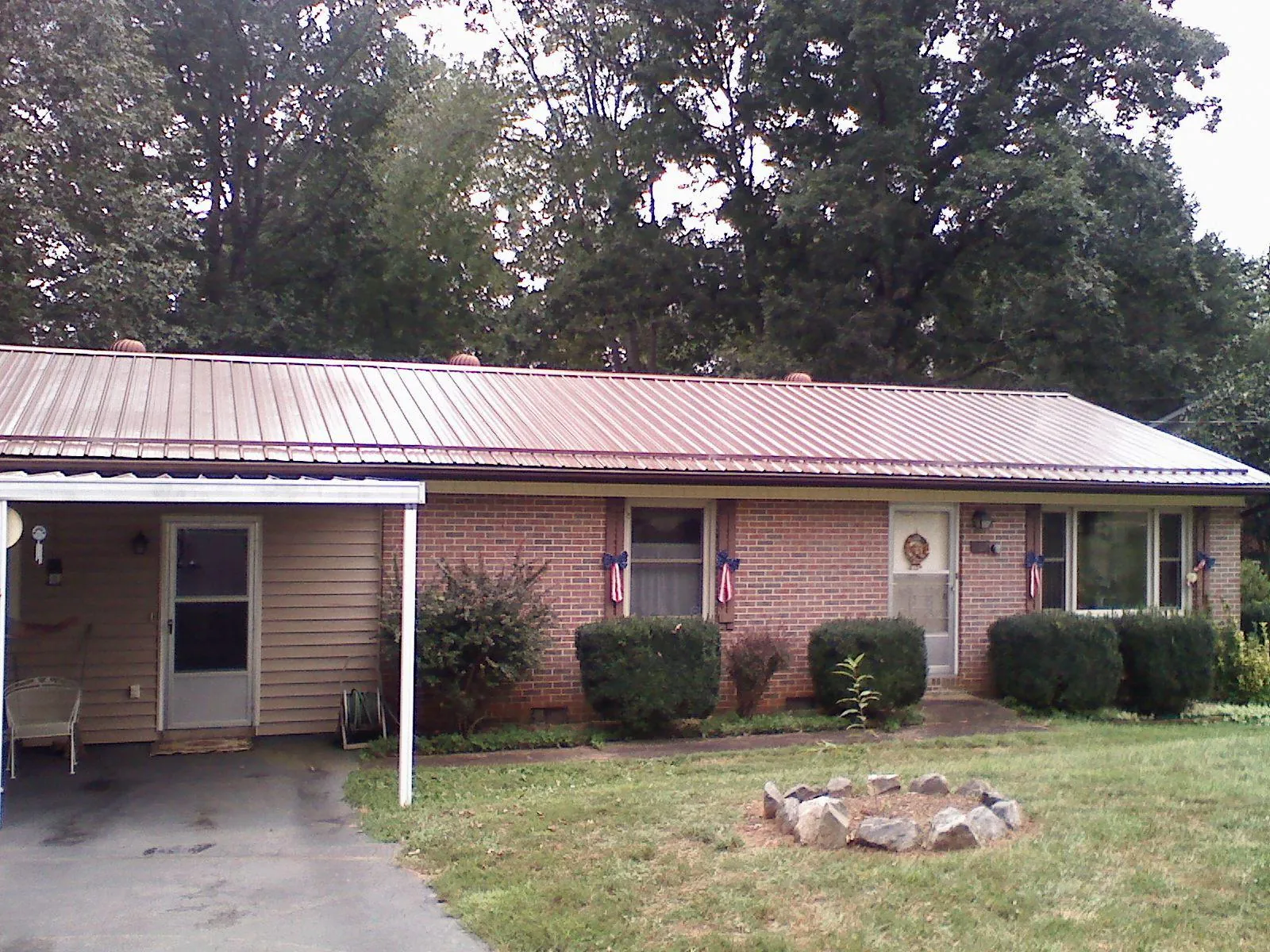 Bronze metal roof and carport on a brick ranch home — Roof Repair work by our crew in Evant