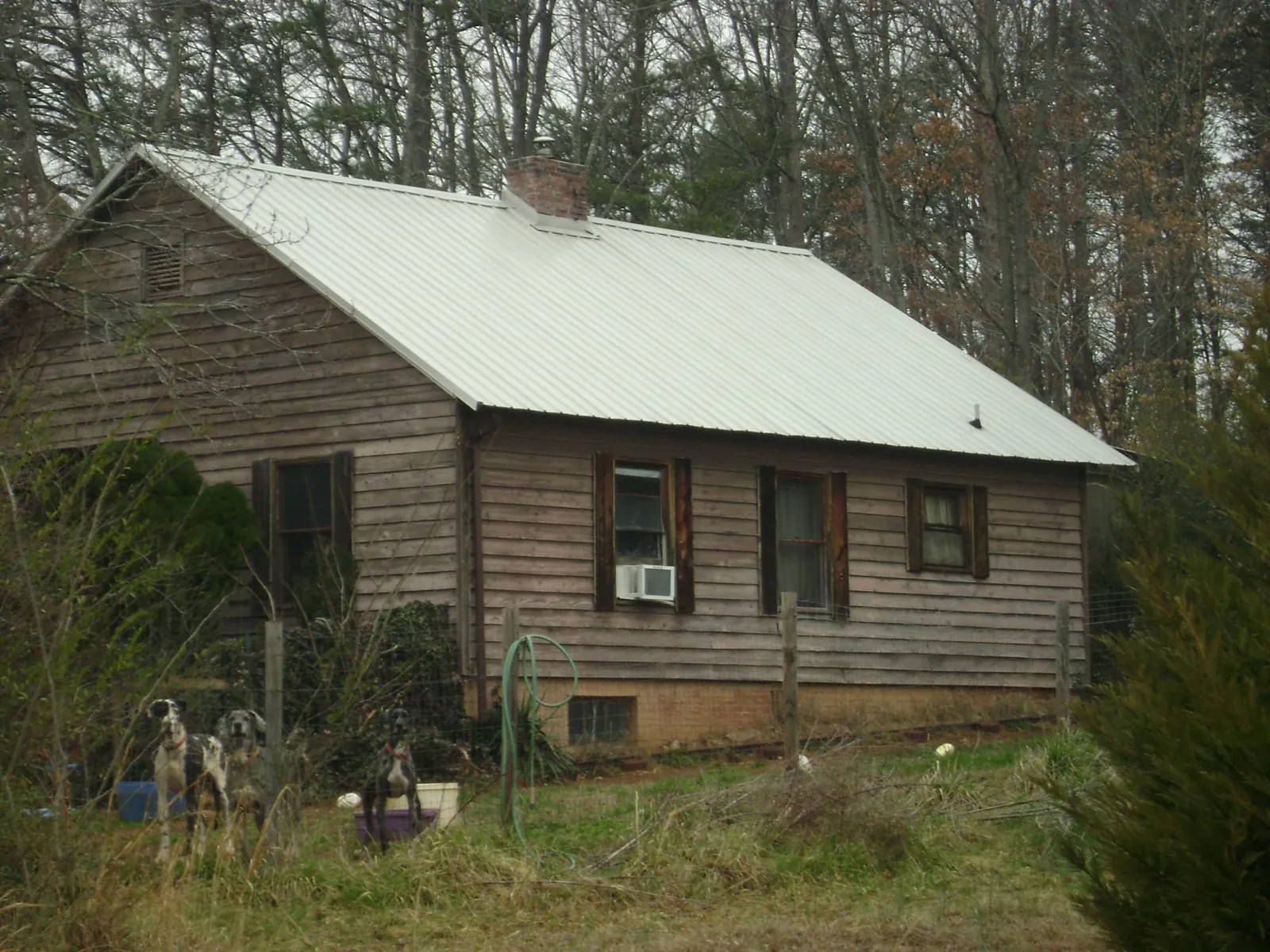 White metal roof on an old wood sided farmhouse, from a Metal Roof Installation job in Evant